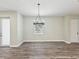 Bright dining area featuring a stylish chandelier, natural light, and wood-look vinyl flooring at 4237 Marine Pkwy, New Port Richey, FL 34652