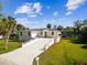 Attractive one-story home featuring a large driveway, manicured lawn, and well-maintained landscaping at 4237 Marine Pkwy, New Port Richey, FL 34652