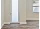 Bright living room featuring wood-look floors, white trim, and frosted glass door at 4237 Marine Pkwy, New Port Richey, FL 34652