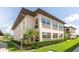 Exterior shot of two-story condo building with manicured lawn and mature trees at 4557 Garnet Dr # 102, New Port Richey, FL 34652