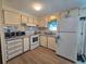 Compact kitchen featuring white cabinets and appliances, including a microwave and oven at 5102 Pigeon Plum Cir, New Port Richey, FL 34653