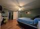 The spacious main bedroom has wood laminate flooring, ceiling fan, and access to ensuite bathroom and closet at 5102 Pigeon Plum Cir, New Port Richey, FL 34653