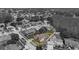Monochrome aerial view highlighting a property with a pool and screened enclosure in a green, landscaped yard at 5412 Merkin Pl, New Port Richey, FL 34655