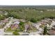 Aerial shot of a residential community with lush trees and greenery, showcasing a home with a screened-in pool at 5412 Merkin Pl, New Port Richey, FL 34655