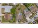 Aerial view of a property featuring a screened pool, fenced yard, and surrounded by lush landscaping at 5412 Merkin Pl, New Port Richey, FL 34655