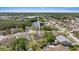 A stunning aerial view of a waterfront home with a private pool in a lush, green neighborhood near a tranquil lake at 5412 Merkin Pl, New Port Richey, FL 34655