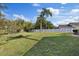 Expansive backyard features mature trees, lush grass, and a sturdy white fence, perfect for outdoor activities at 5412 Merkin Pl, New Port Richey, FL 34655