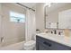 Cozy bathroom featuring a shower-tub combo, modern vanity with sink, and a bright window at 5412 Merkin Pl, New Port Richey, FL 34655