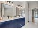 Updated bathroom featuring blue cabinets with double sinks, vanity lighting, and modern fixtures at 5412 Merkin Pl, New Port Richey, FL 34655