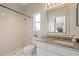 Bright bathroom with granite countertop, tiled shower and flooring, and a view into the kitchen at 5412 Merkin Pl, New Port Richey, FL 34655