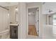 View of a bathroom with a vanity, opening into another room with light wood floors at 5412 Merkin Pl, New Port Richey, FL 34655