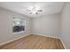 A comfortable bedroom showcasing a ceiling fan, window with blinds and vinyl floors at 5412 Merkin Pl, New Port Richey, FL 34655