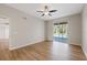 The bedroom features wood floors, neutral paint, a ceiling fan, and a sliding glass door to the lanai at 5412 Merkin Pl, New Port Richey, FL 34655