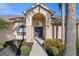Close up of the front door framed by mature landscaping and an arched entryway at 5412 Merkin Pl, New Port Richey, FL 34655