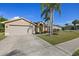 Inviting single-story home with a well-kept lawn and a spacious driveway leading to an attached garage at 5412 Merkin Pl, New Port Richey, FL 34655