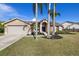 Charming single-story home featuring a well-maintained lawn, mature palm trees, and a two-car garage at 5412 Merkin Pl, New Port Richey, FL 34655