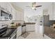 Well-lit kitchen featuring white cabinets, granite countertops, stainless appliances, and an opening to the living area at 5412 Merkin Pl, New Port Richey, FL 34655