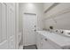 Bright laundry room with white appliances, overhead shelf and a door to the exterior of the property at 5412 Merkin Pl, New Port Richey, FL 34655
