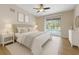 A well-lit main bedroom with a ceiling fan, with sliding glass doors leading to a view of the pool at 5412 Merkin Pl, New Port Richey, FL 34655