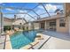 Relaxing pool area with rock waterfall feature and screened enclosure to protect the pool and decking at 5412 Merkin Pl, New Port Richey, FL 34655