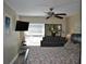 A bedroom with a large window, ceiling fan, a TV, and a queen-size bed at 6037 Chesham Dr # 3, New Port Richey, FL 34653