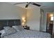A bedroom with a large window, ceiling fan, a TV, and a queen-size bed and access to the ensuite bathroom at 6037 Chesham Dr # 3, New Port Richey, FL 34653