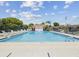 Wide view of a community swimming pool with lounge chairs under a partly cloudy sky at 6037 Chesham Dr # 3, New Port Richey, FL 34653