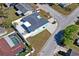 Aerial view of turquoise house with a fenced yard and neighboring pool at 7221 Westwind Dr, Port Richey, FL 34668