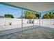 Backyard with gray pavers, string lights, and a white privacy fence with a palm tree at 7221 Westwind Dr, Port Richey, FL 34668