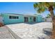 Beautiful backyard with a large gray brick patio, palm trees, and a light blue house exterior at 7221 Westwind Dr, Port Richey, FL 34668