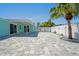 Spacious backyard with gray pavers, a covered patio, and a white privacy fence at 7221 Westwind Dr, Port Richey, FL 34668