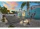 Backyard view of a light blue house with gray stone paver patio, white privacy fence, and palm trees in the yard at 7221 Westwind Dr, Port Richey, FL 34668