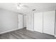Bedroom with light gray walls, wood-look floors, a ceiling fan, and double closets at 7221 Westwind Dr, Port Richey, FL 34668