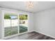 This bedroom features gray wood-look floors and a sliding glass door to the patio at 7221 Westwind Dr, Port Richey, FL 34668