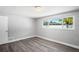 Bright bedroom features new flooring, fresh paint, and a window with a view of the outdoors at 7221 Westwind Dr, Port Richey, FL 34668