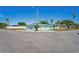 Exterior view of a turquoise home at a corner with mature palm trees at 7221 Westwind Dr, Port Richey, FL 34668