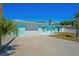 Beautiful exterior view of a light blue home with an attached garage and a well-maintained lawn at 7221 Westwind Dr, Port Richey, FL 34668