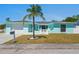 Charming one-story home featuring a well-maintained yard, light blue exterior, and a palm tree in the front at 7221 Westwind Dr, Port Richey, FL 34668
