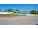 Exterior shot of turquoise house with white fence, well-kept lawn and curb appeal at 7221 Westwind Dr, Port Richey, FL 34668
