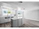 Bright renovated kitchen with a gray island, stainless steel appliances, and hardwood floors at 7221 Westwind Dr, Port Richey, FL 34668