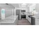 Bright renovated kitchen with a gray island, stainless steel appliances, white cabinets and hardwood floors at 7221 Westwind Dr, Port Richey, FL 34668