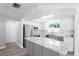 Bright renovated kitchen with a gray island, stainless steel appliances, white cabinets and hardwood floors at 7221 Westwind Dr, Port Richey, FL 34668