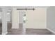 Living space showcasing an open doorway and rustic sliding door, complete with sleek gray flooring at 7221 Westwind Dr, Port Richey, FL 34668
