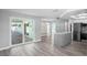 Open-concept living area featuring modern gray flooring and a sliding glass door to the outdoor patio at 7221 Westwind Dr, Port Richey, FL 34668