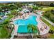Aerial view of the community clubhouse and swimming pool, nestled within a lush landscape and lake at 7511 Melogold Cir, Land O Lakes, FL 34637