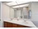 Bathroom boasts a double vanity with wood cabinets, white countertops, and a large mirror at 7511 Melogold Cir, Land O Lakes, FL 34637