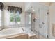 Modern bathroom featuring a soaking tub and a frameless glass shower with tiled surround at 7511 Melogold Cir, Land O Lakes, FL 34637