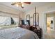 Bedroom features a four-poster bed, dresser, and ample natural light, creating a cozy space at 7511 Melogold Cir, Land O Lakes, FL 34637