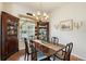 Elegant dining room featuring a chandelier, classic decor, and a charming window with blinds at 7511 Melogold Cir, Land O Lakes, FL 34637