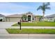Charming single-story home featuring lush landscaping, palm trees, and a welcoming facade at 7511 Melogold Cir, Land O Lakes, FL 34637